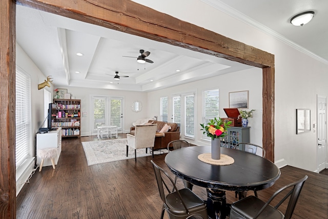 dining room with dark hardwood / wood-style floors, ornamental molding, and a raised ceiling