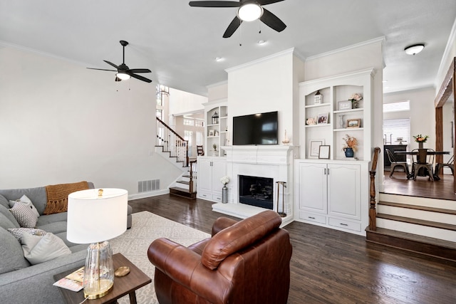 living room featuring a healthy amount of sunlight, dark wood-type flooring, and built in features