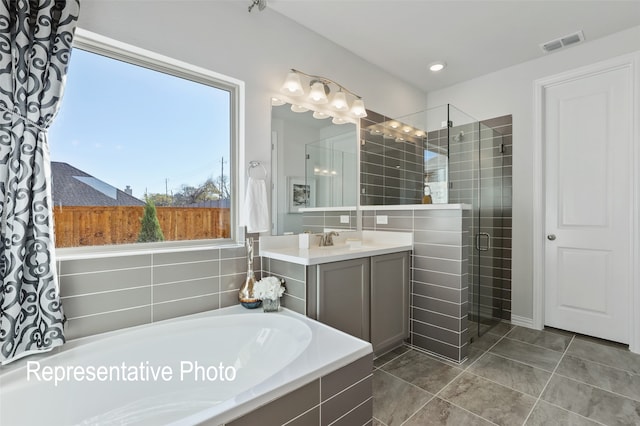 bathroom with tile patterned floors, vanity, and independent shower and bath