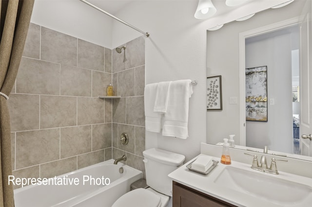 full bathroom featuring toilet, tiled shower / bath, and vanity