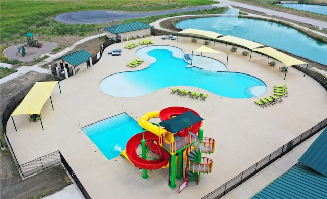 view of swimming pool with a playground and a water slide