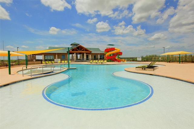 view of pool featuring a playground, a patio, and a water slide