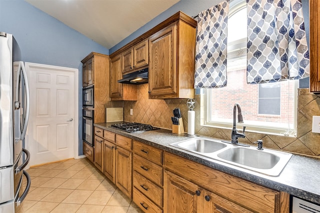 kitchen with vaulted ceiling, black appliances, decorative backsplash, sink, and light tile patterned flooring