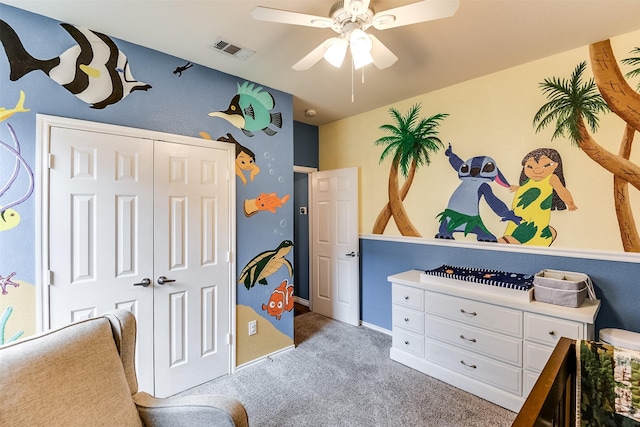 carpeted bedroom with ceiling fan and a closet