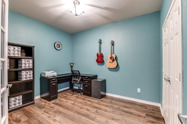 office space featuring a textured ceiling and light hardwood / wood-style flooring