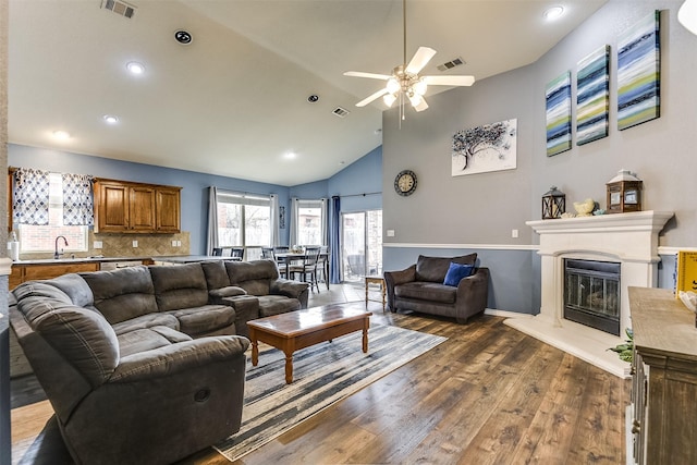 living room featuring high vaulted ceiling, ceiling fan, dark wood-type flooring, and sink