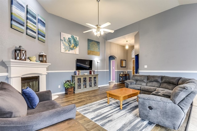 living room featuring light hardwood / wood-style floors, ceiling fan, and vaulted ceiling