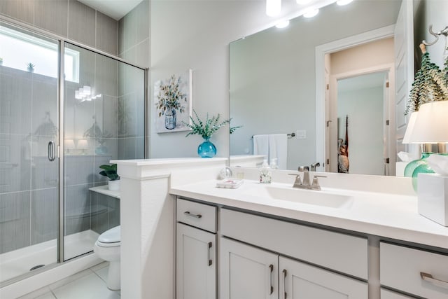 bathroom featuring tile patterned flooring, vanity, toilet, and a shower with shower door