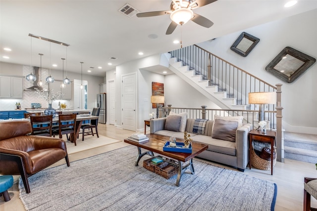 living room with ceiling fan and light hardwood / wood-style floors