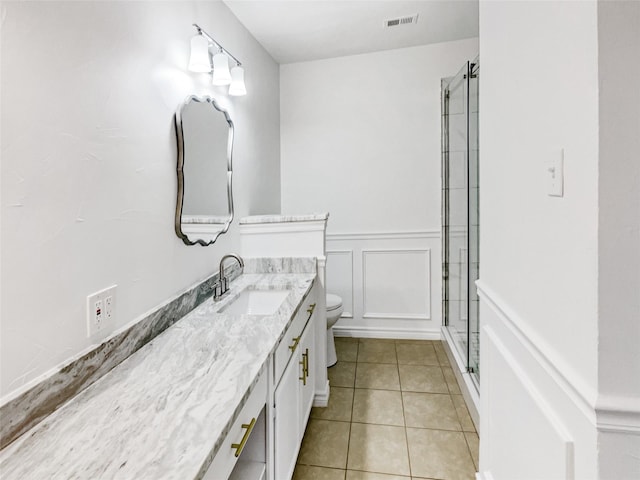 bathroom with toilet, vanity, walk in shower, and tile patterned flooring