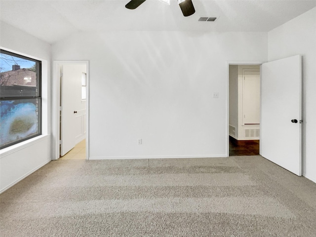 empty room with light carpet, vaulted ceiling, and ceiling fan