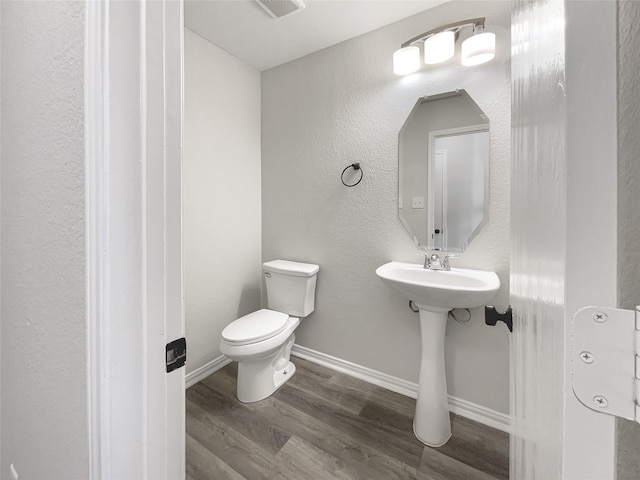 bathroom featuring toilet and wood-type flooring