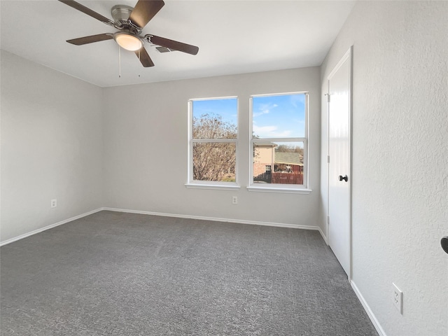 unfurnished room featuring ceiling fan and dark carpet