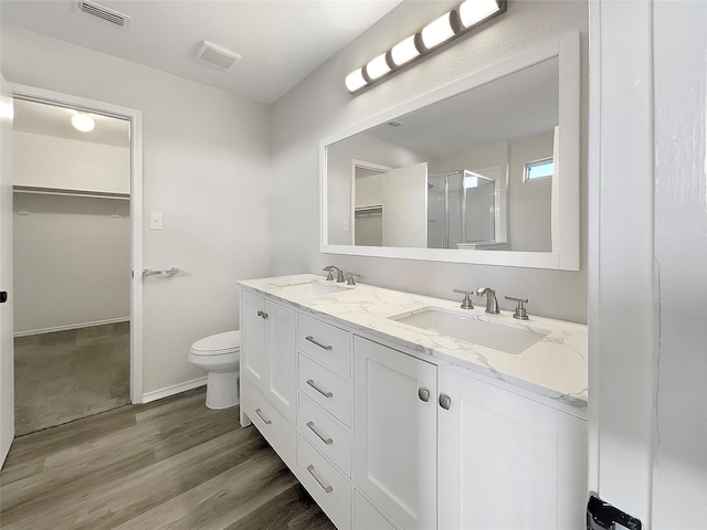 bathroom featuring vanity, toilet, an enclosed shower, and wood-type flooring