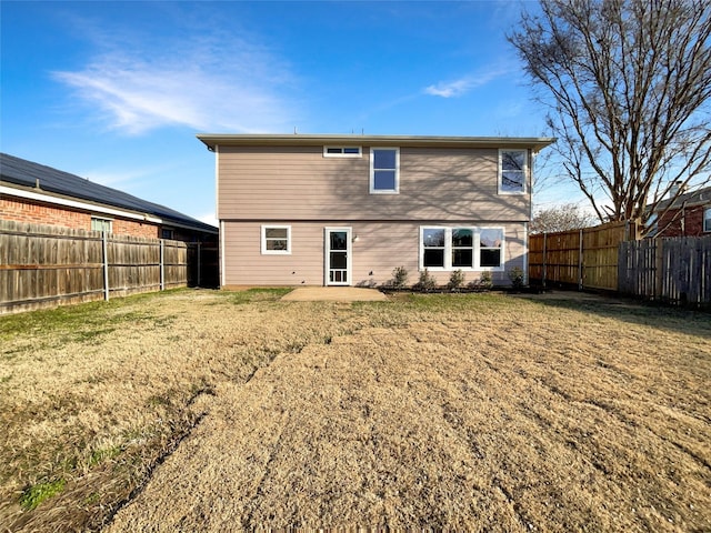 rear view of house featuring a patio area and a yard