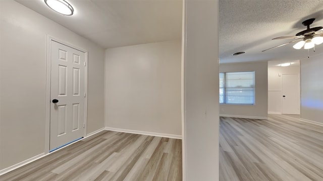 empty room featuring ceiling fan, a textured ceiling, and light hardwood / wood-style floors