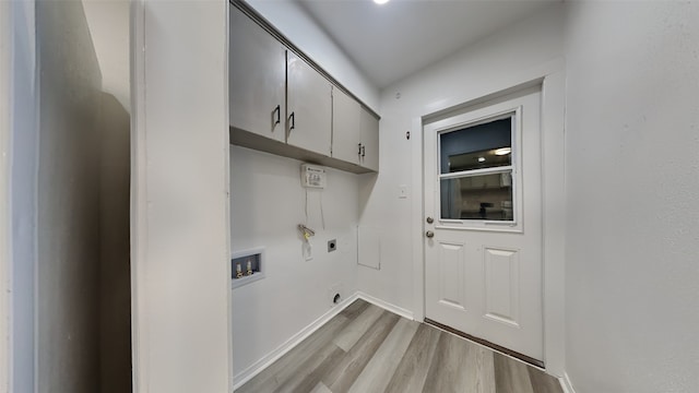 washroom with light hardwood / wood-style flooring, washer hookup, electric dryer hookup, and cabinets