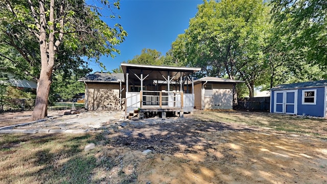 rear view of property with a storage shed