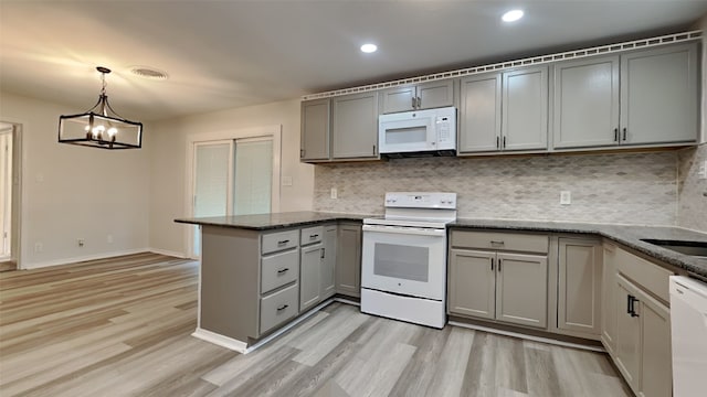 kitchen with tasteful backsplash, gray cabinets, pendant lighting, kitchen peninsula, and white appliances