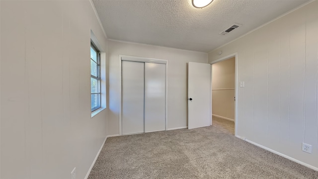 unfurnished bedroom featuring light carpet, a closet, a textured ceiling, and multiple windows