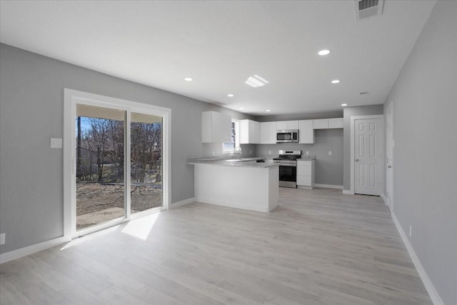 kitchen with white cabinets, plenty of natural light, visible vents, and stainless steel appliances