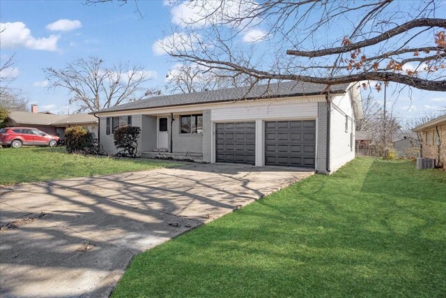 ranch-style home featuring a garage, a front lawn, and central air condition unit