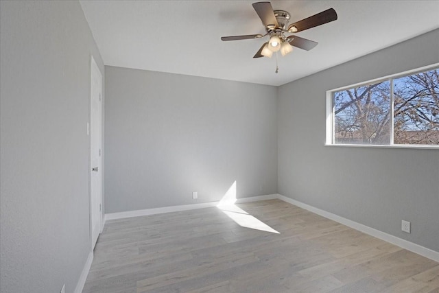 empty room featuring wood finished floors, a ceiling fan, and baseboards