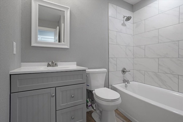 bathroom with a textured wall,  shower combination, vanity, and toilet