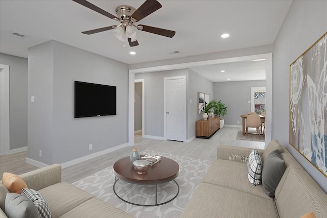 living room featuring ceiling fan and light hardwood / wood-style flooring