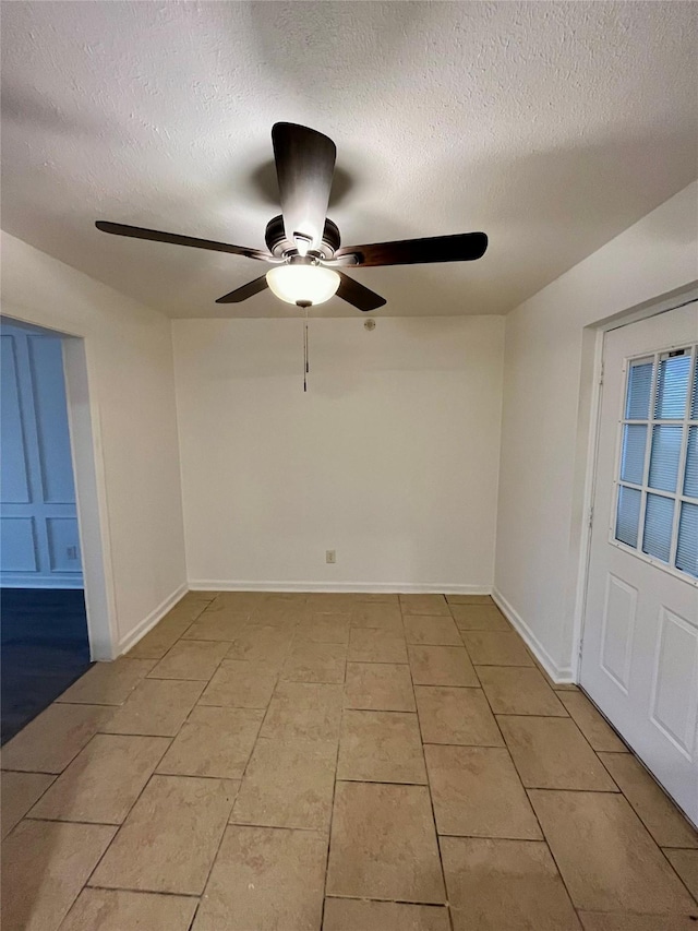 unfurnished room with ceiling fan, light tile patterned floors, and a textured ceiling