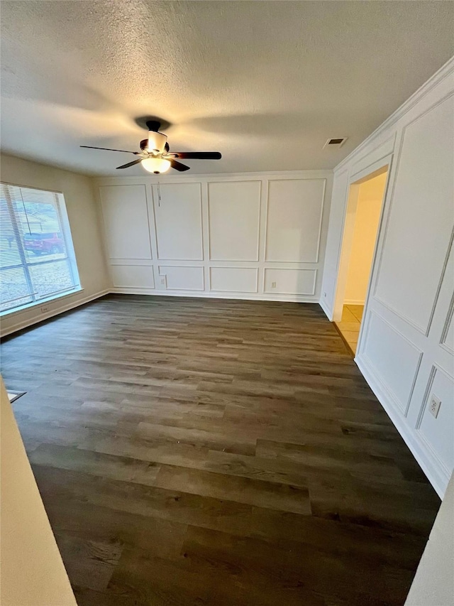 interior space with a textured ceiling, dark wood-type flooring, and ceiling fan