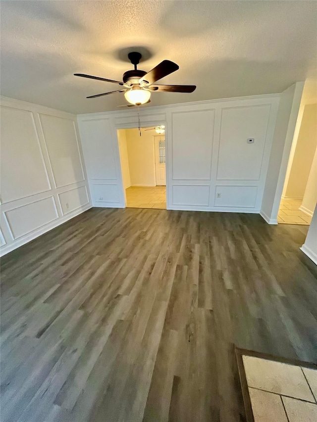 unfurnished bedroom with hardwood / wood-style flooring, ceiling fan, a closet, and a textured ceiling