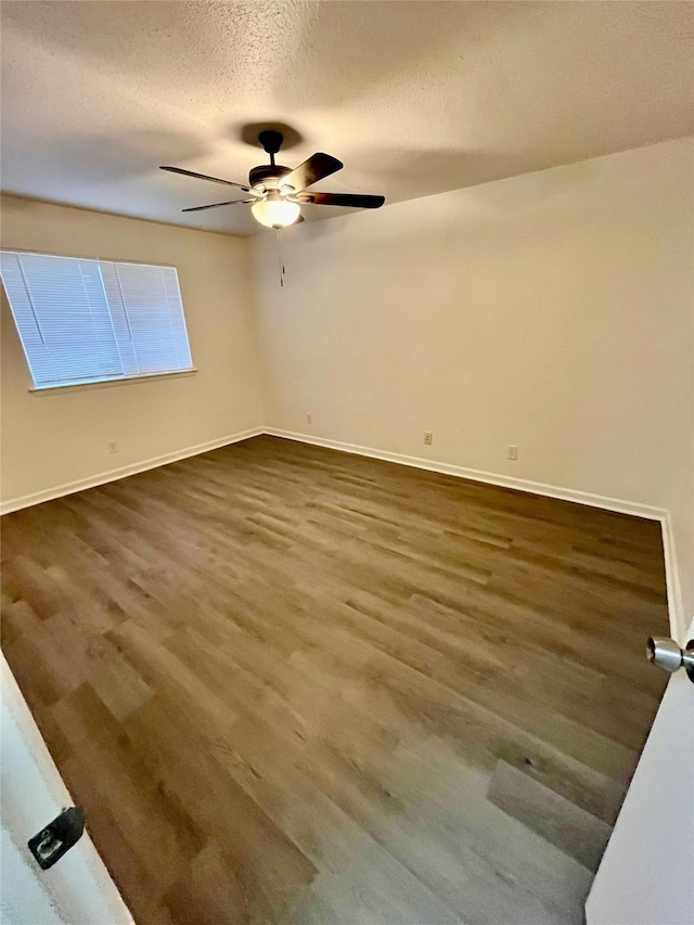 unfurnished room with dark hardwood / wood-style flooring, ceiling fan, and a textured ceiling