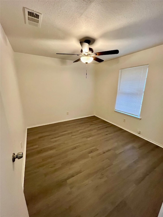 unfurnished room featuring ceiling fan, dark hardwood / wood-style floors, and a textured ceiling