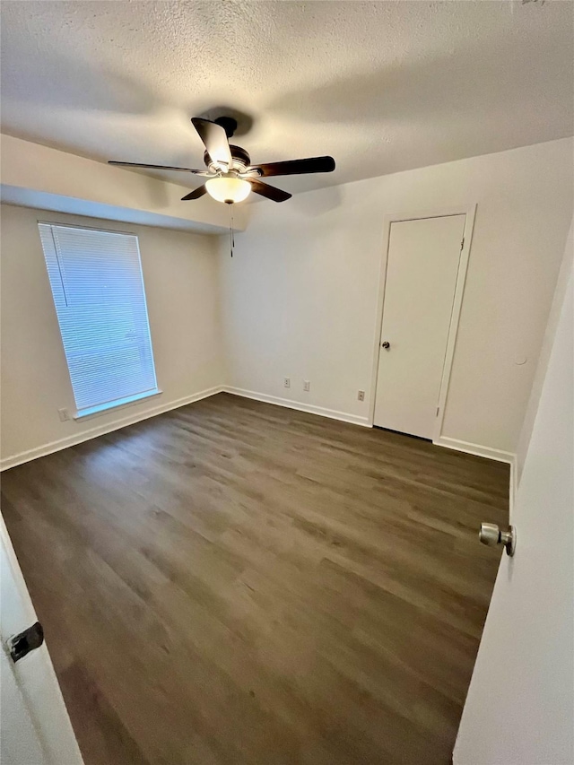 spare room with ceiling fan, dark hardwood / wood-style floors, and a textured ceiling