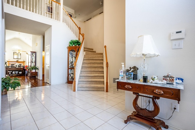 entryway with light tile patterned floors and high vaulted ceiling