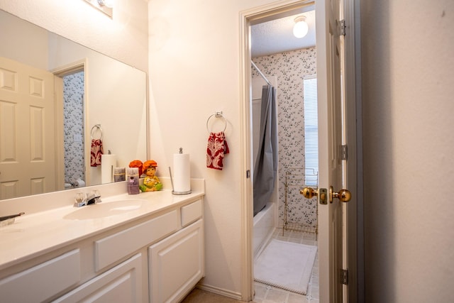 bathroom with a textured ceiling, vanity, and shower / tub combo