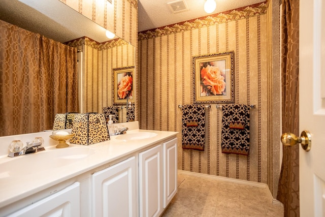 bathroom with a textured ceiling and vanity