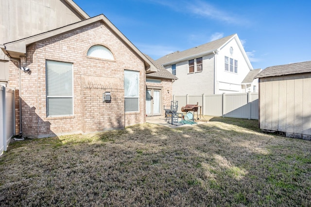 rear view of house featuring a yard and a patio