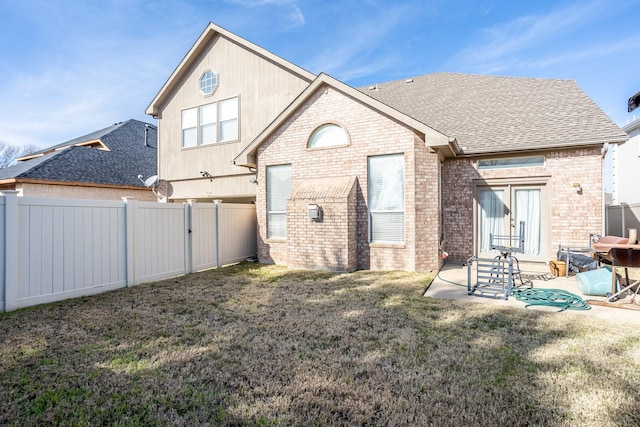 rear view of house with a yard and a patio