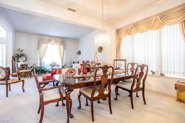 carpeted dining area with ornamental molding and a notable chandelier