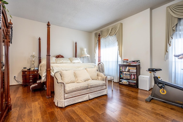 bedroom featuring a textured ceiling and dark hardwood / wood-style flooring