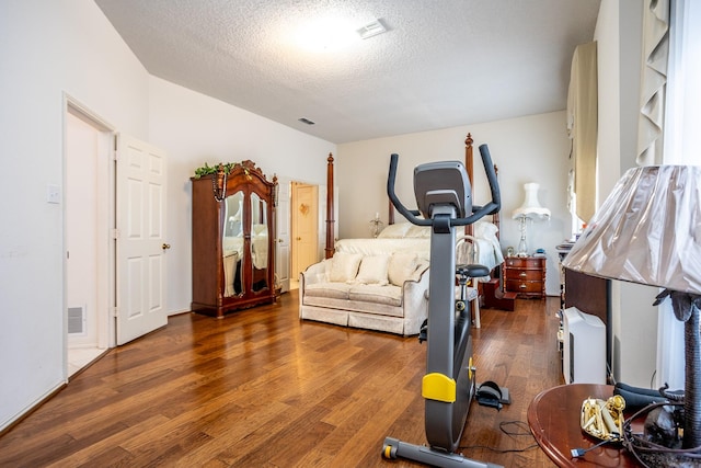 workout room with dark wood-type flooring and a textured ceiling