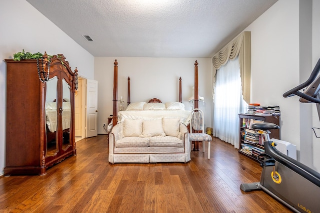 bedroom featuring dark wood-type flooring and a textured ceiling