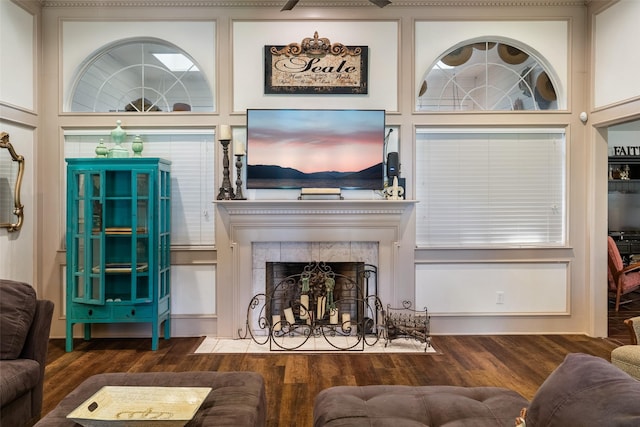 living room with a towering ceiling, dark hardwood / wood-style flooring, and a tiled fireplace