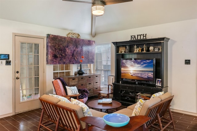 living area featuring ceiling fan and beamed ceiling