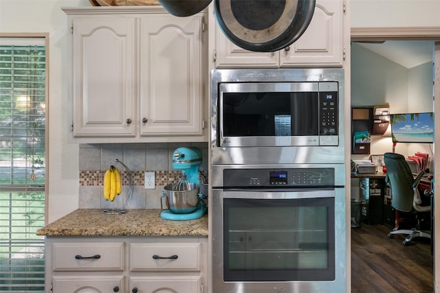 kitchen featuring white cabinets, decorative backsplash, and light stone counters