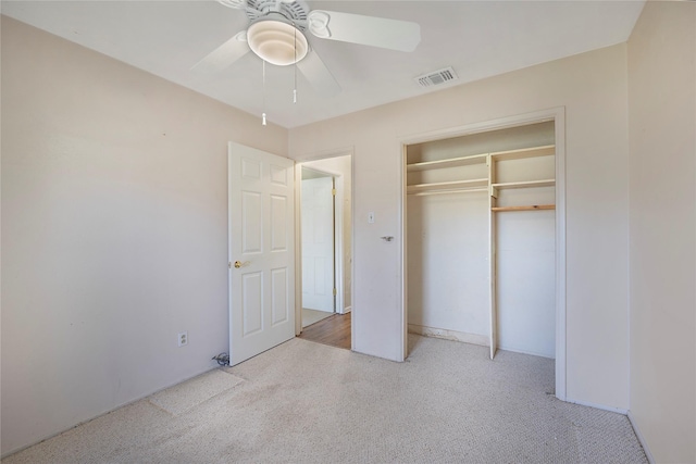 unfurnished bedroom with ceiling fan, light colored carpet, and a closet