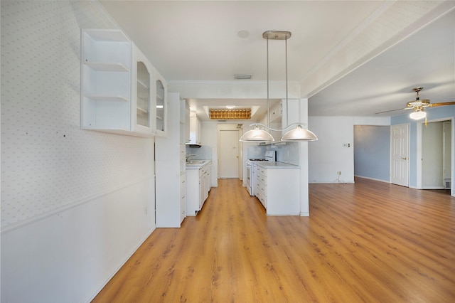 kitchen featuring light hardwood / wood-style floors, hanging light fixtures, white cabinets, white gas range oven, and sink