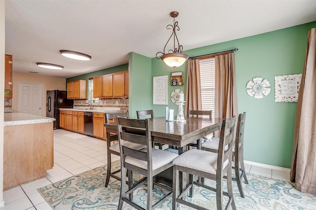 dining area featuring a textured ceiling and light tile patterned floors